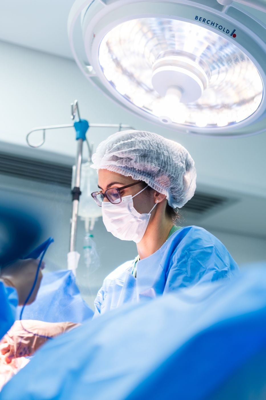 Dra. Svenja concentrada durante cirurgia, sob a luz do foco cirúrgico